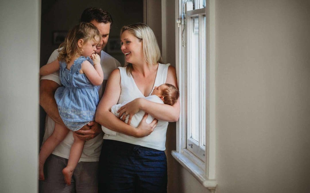 A newborn baby being held by his family