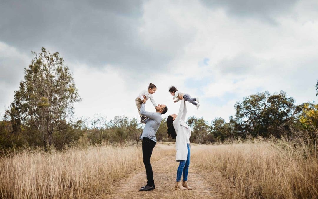 A family swing their boys above them as they play aeroplane games