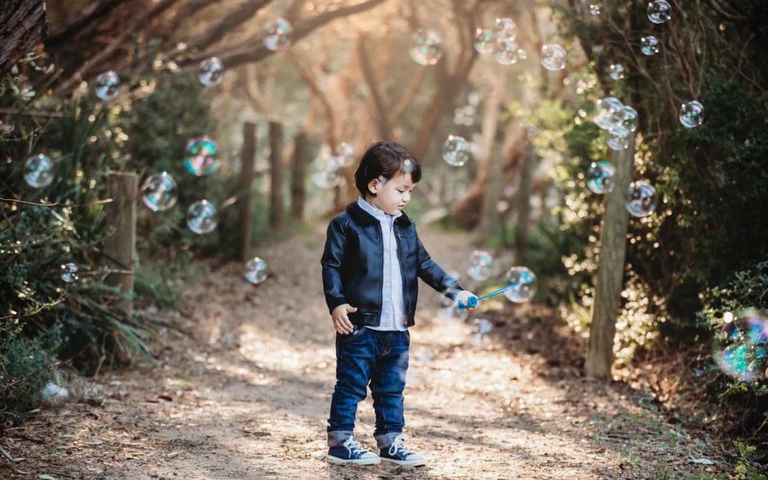 A little boy plays with bubbles in the sunset