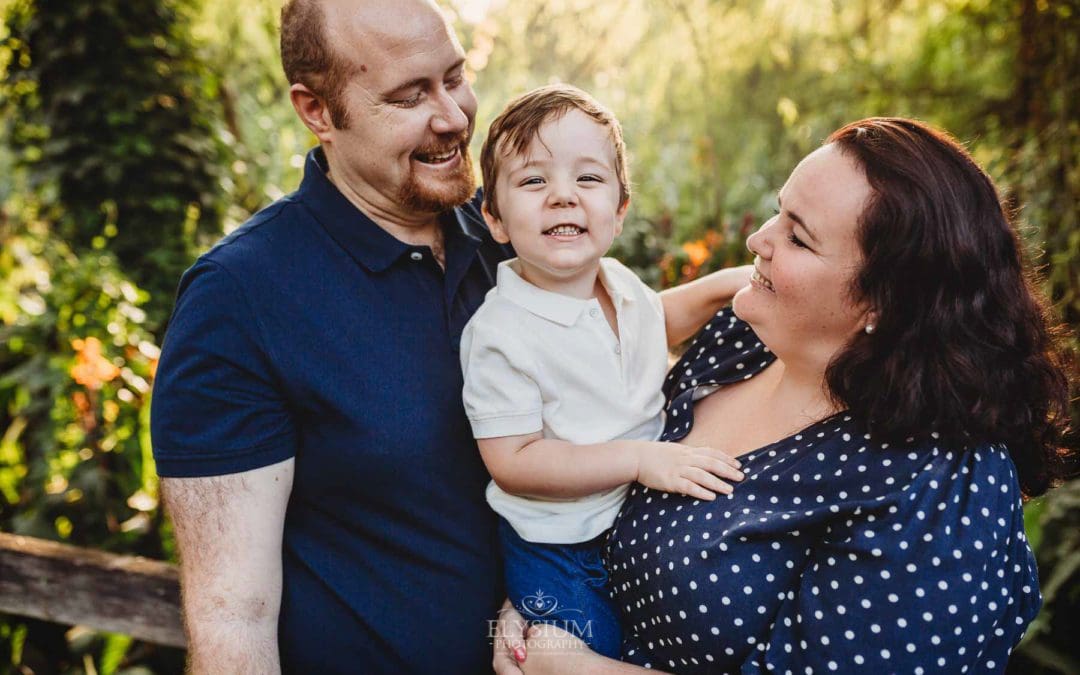 Parents cuddle their little boy between them