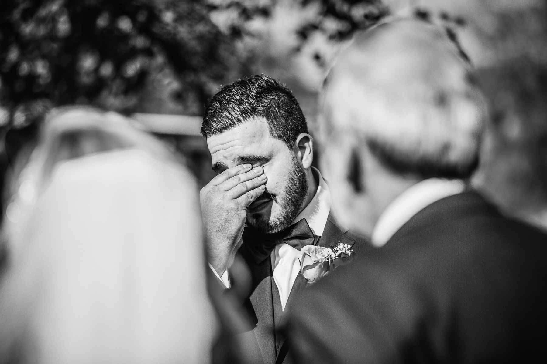 A groom gets emotional as he sees his bride coming down the aisle at Gledswood Estate wedding