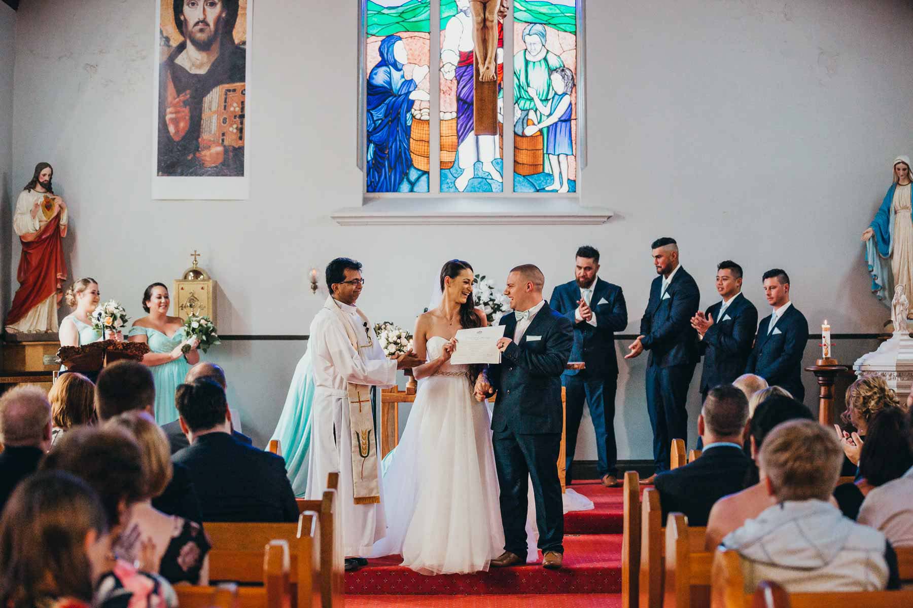 A couple show off their marriage certificate during their church ceremony