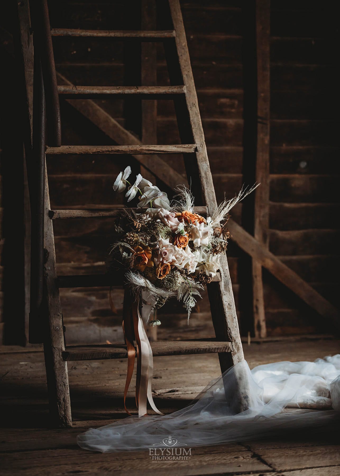 A brides bouquet leans against a rustic ladder at a Belgenny Farm wedding