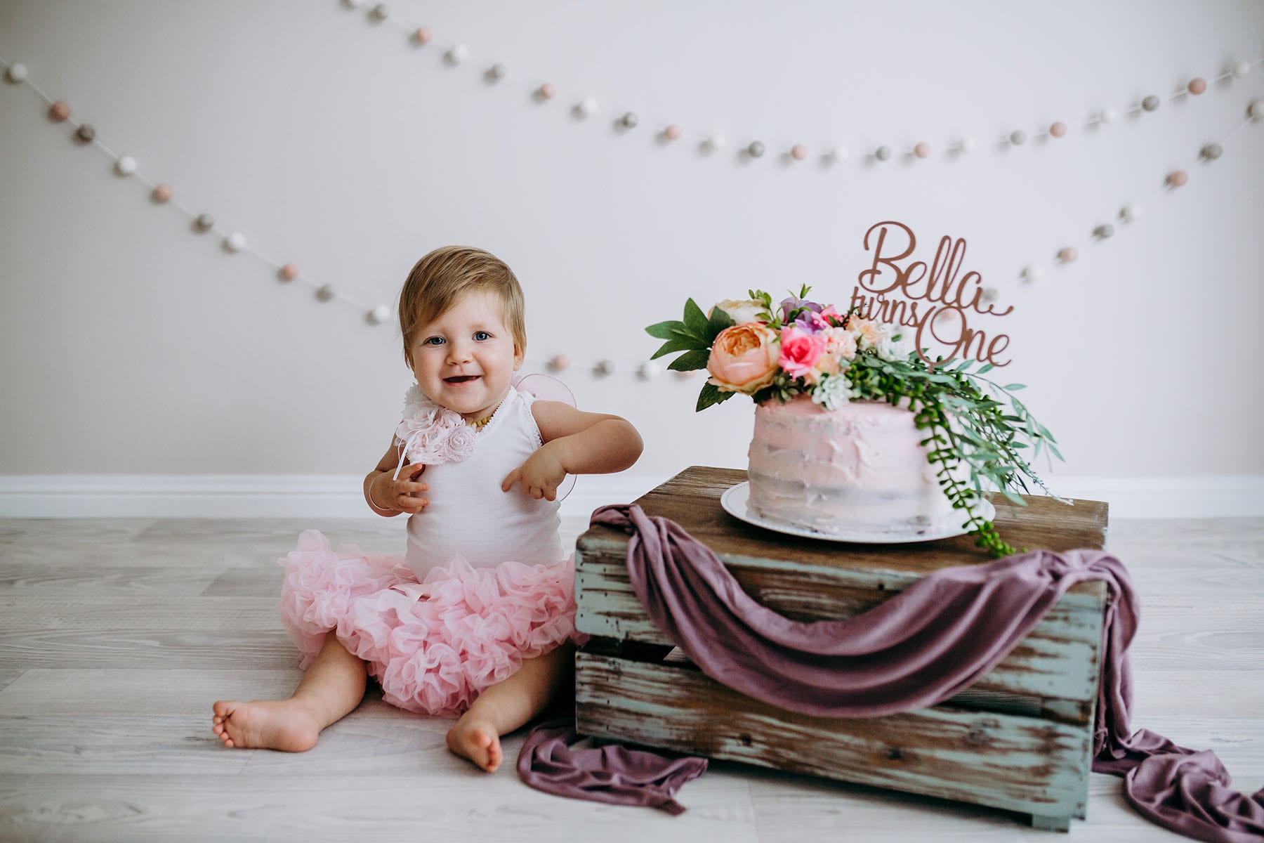 A baby girl looking excited before her cake smash session