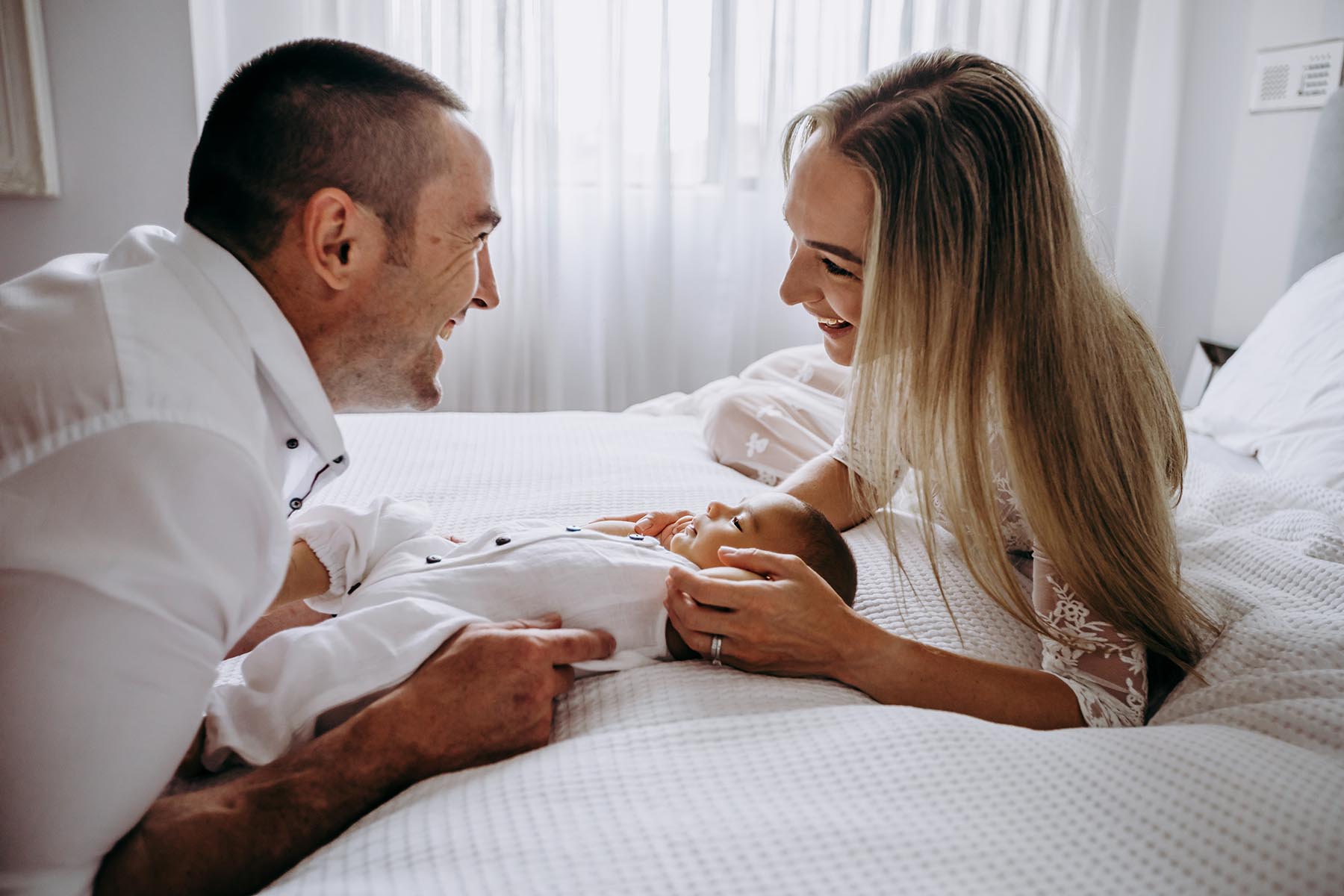 Sydney-Inhome-Newborn-Photographer-Elysium-Photography-Daniil-33 A mum and dad cradle their newborn baby boy on their bed in-home