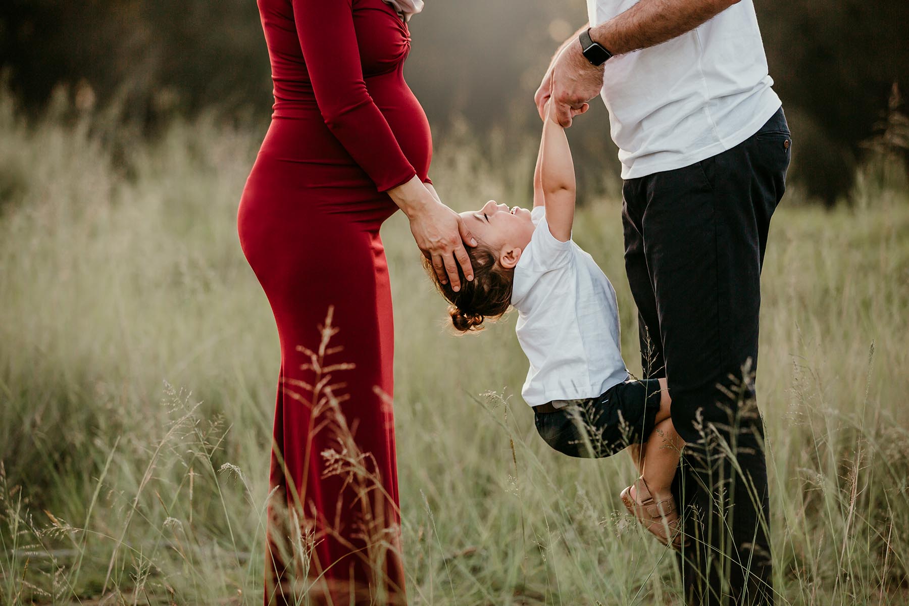 Sydney-Outdoor-Maternity-Photographer-Elysium-Photography-M&A-42 A dad lifts his little boy up, his pregnant mother strokes his head as he giggles