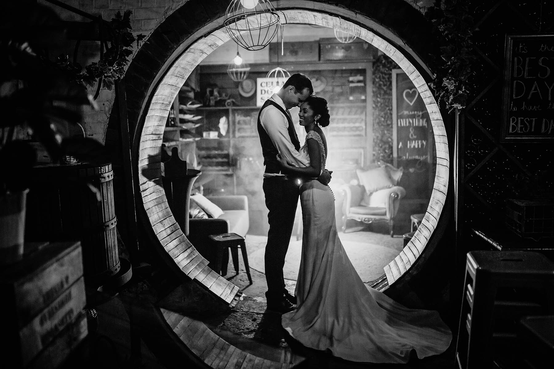 A bride and groom cuddle in a circular doorway at their Gledswood Estate wedding