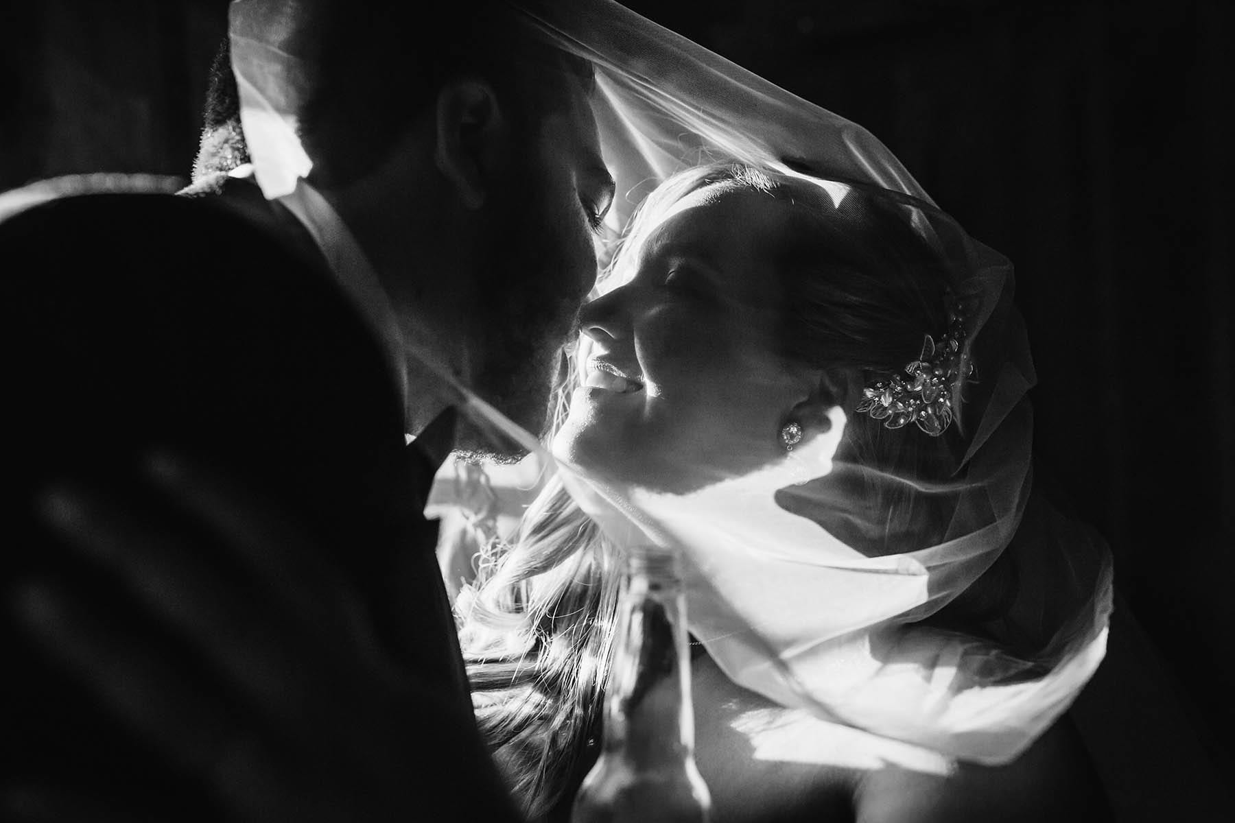 A bride and groom share a kiss under the veil after their Gledswood Wedding