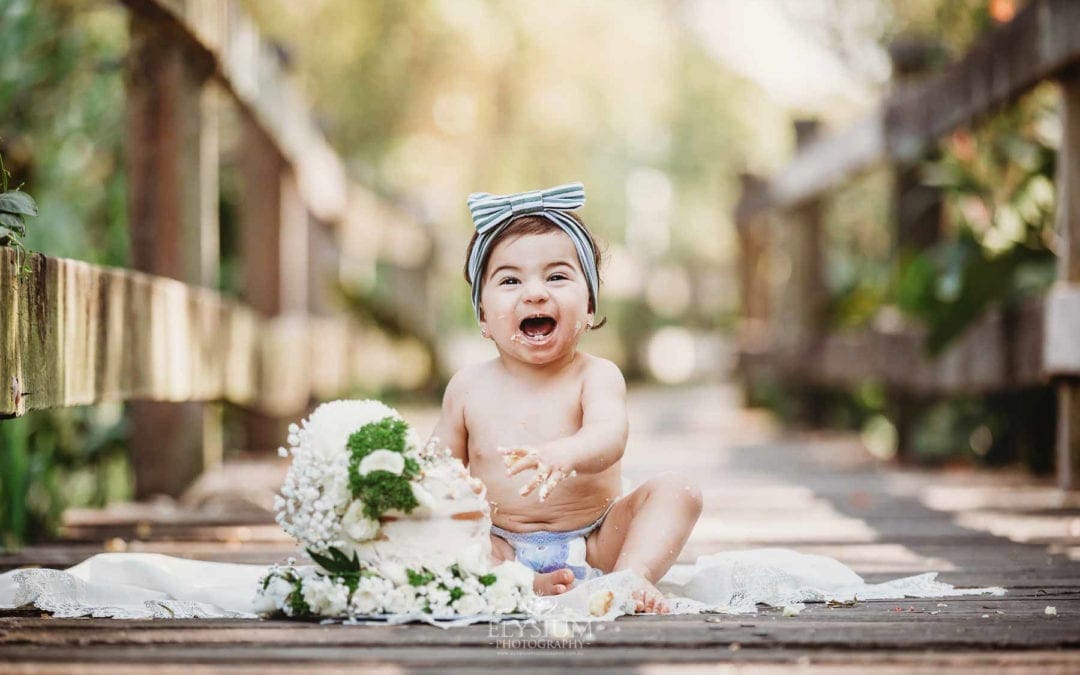 Family Photographer - A little baby sits in front of her cake