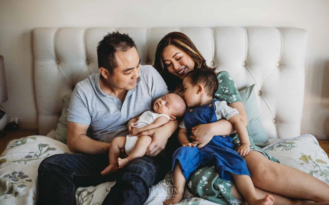 Newborn Session - a little boy kisses his newborn brothers head