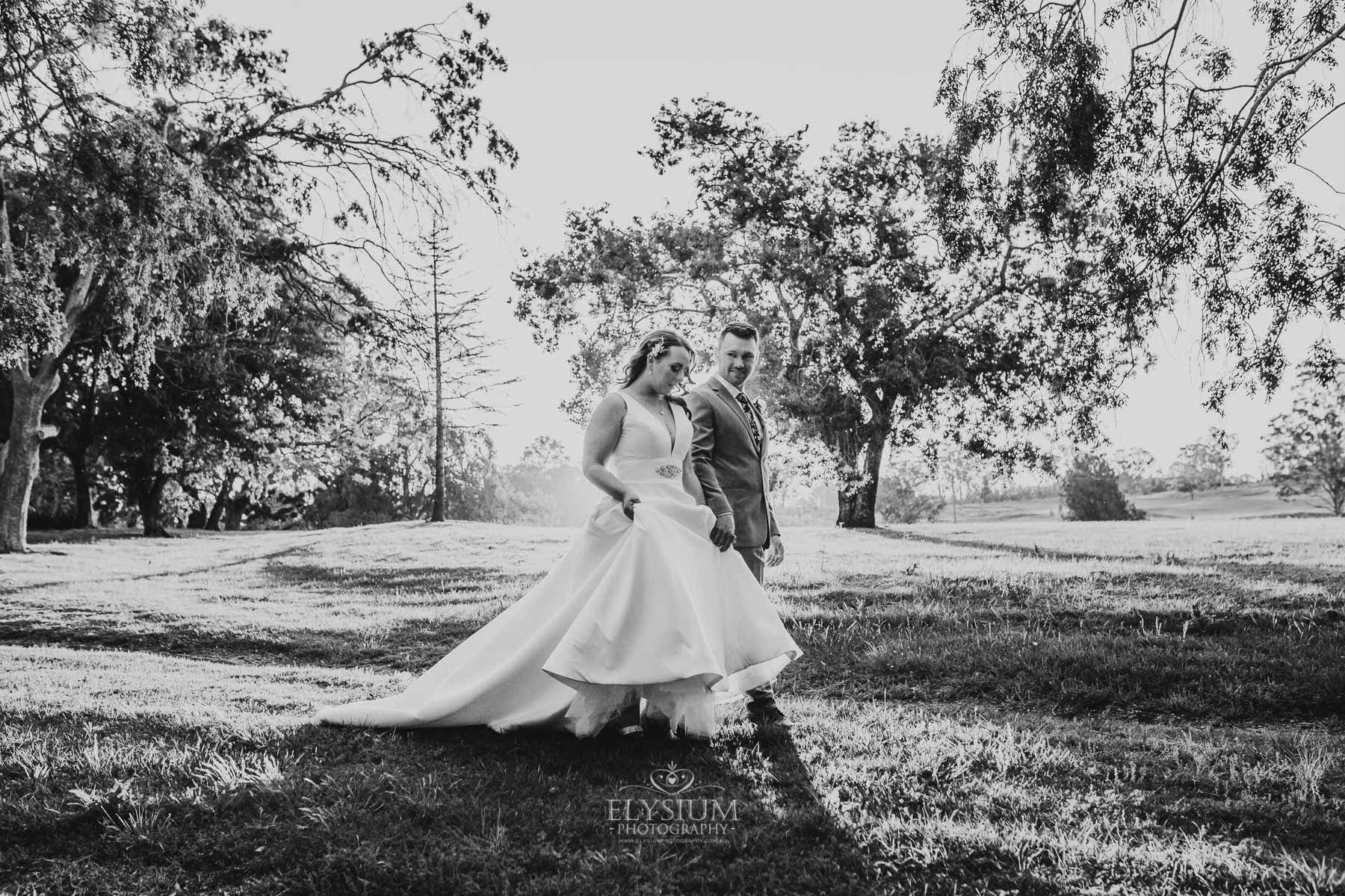 Gledswood Wedding - bride and groom walk along the venue driveway