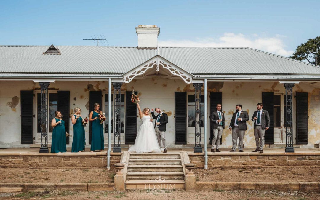 Gledswood Wedding Photo - Newlyweds fist pump in celebration with the bridal party