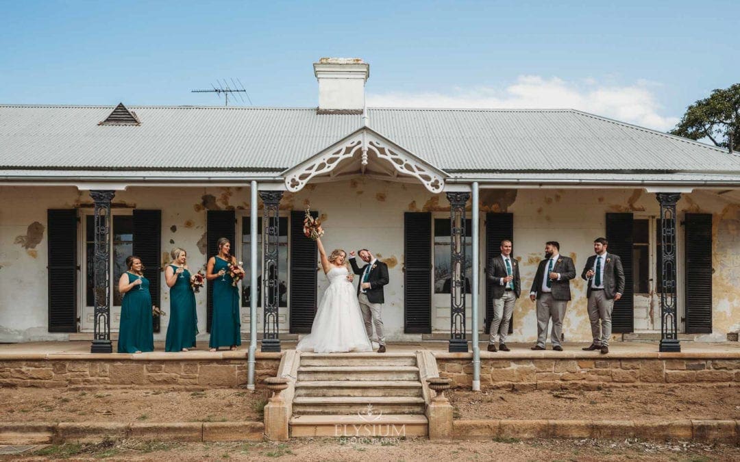 Gledswood Wedding Photo - Newlyweds fist pump in celebration with the bridal party