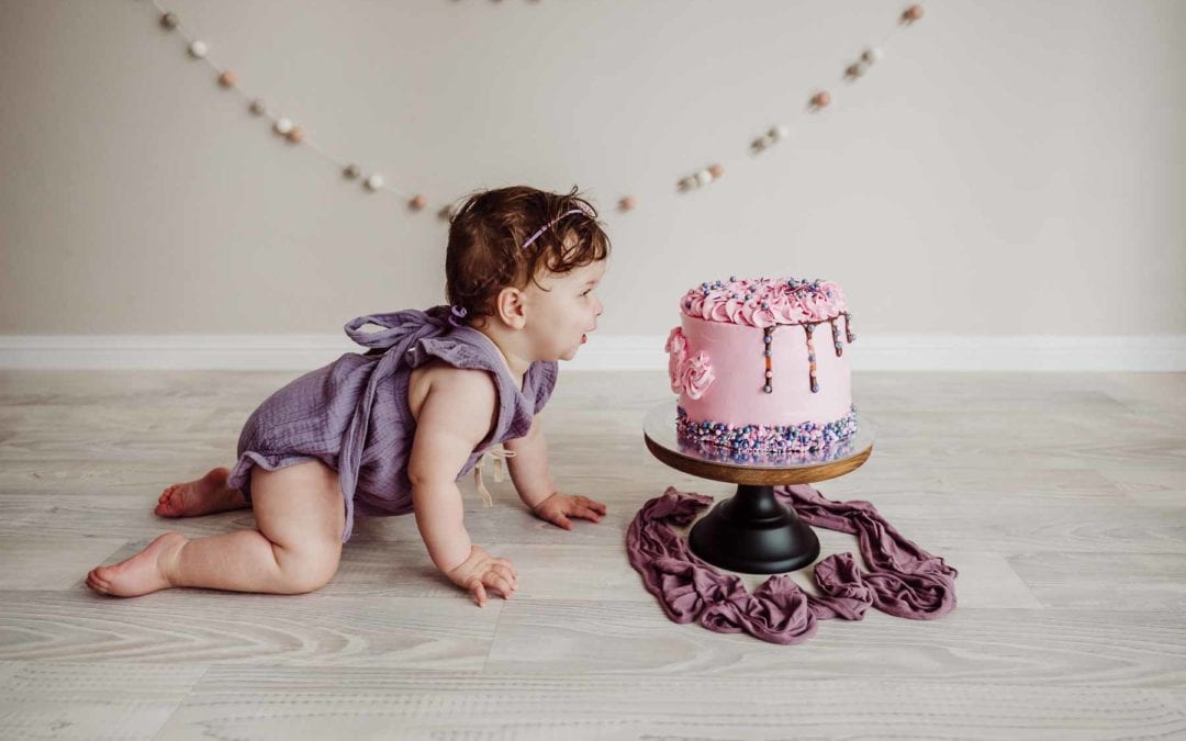 Cake Smash Session - baby girl crawls to look at her pink cake