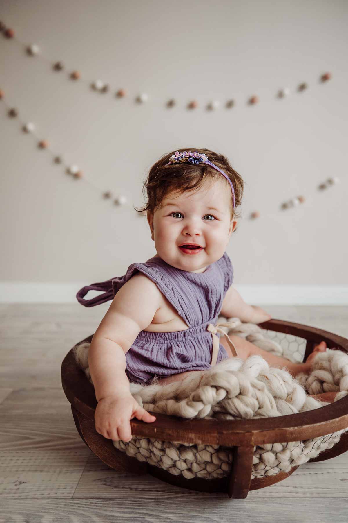 Cake Smash Session - baby girl sits on a blanket in a wooden bowl