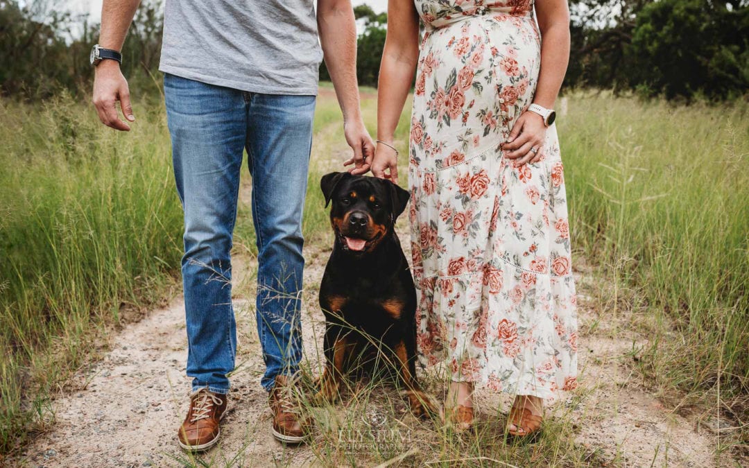 Maternity Photographer - a couple stand with their fur baby between them