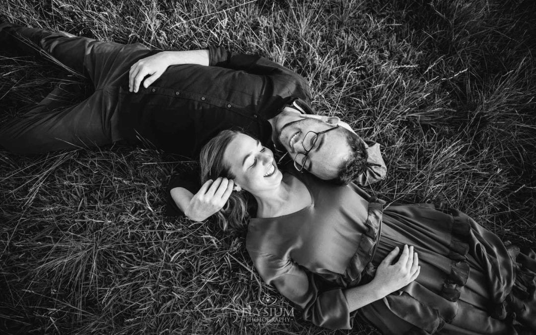 Engagement Photography - a couple lay together in long grass