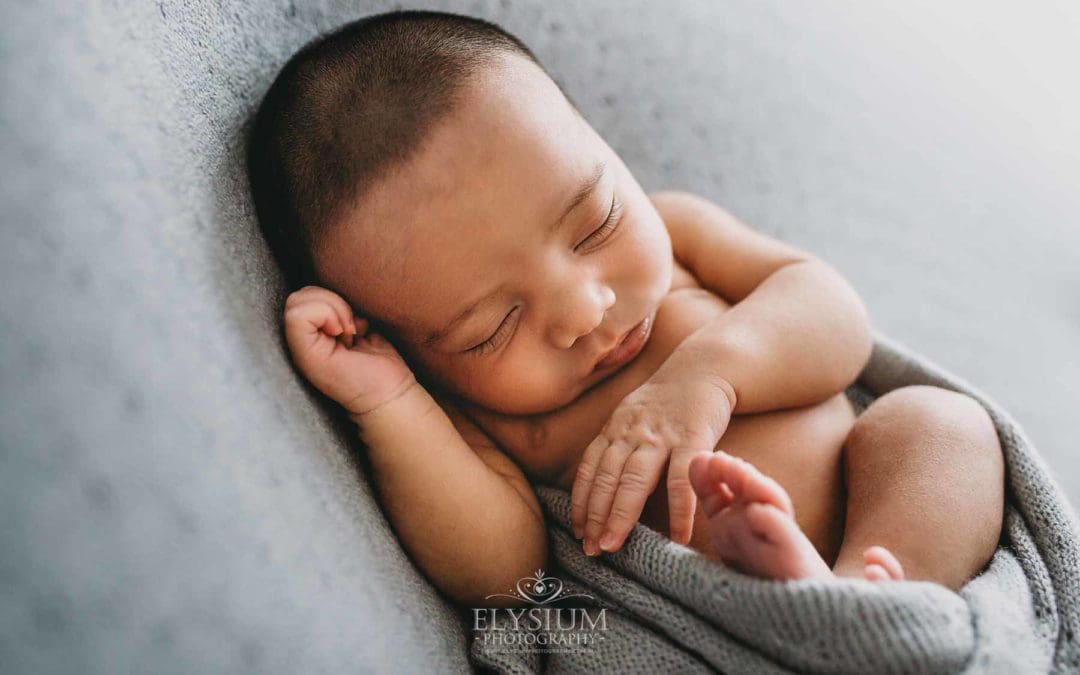 A newborn baby lays sleeping in a great wrap