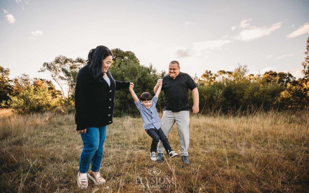 Family Photography: parents walk swinging their little boy between them