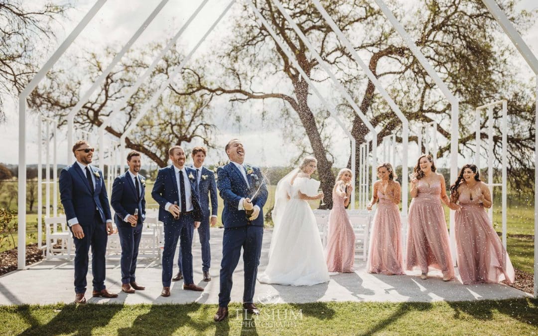 The bridal party pop a champaign bottle and shake it after the wedding ceremony