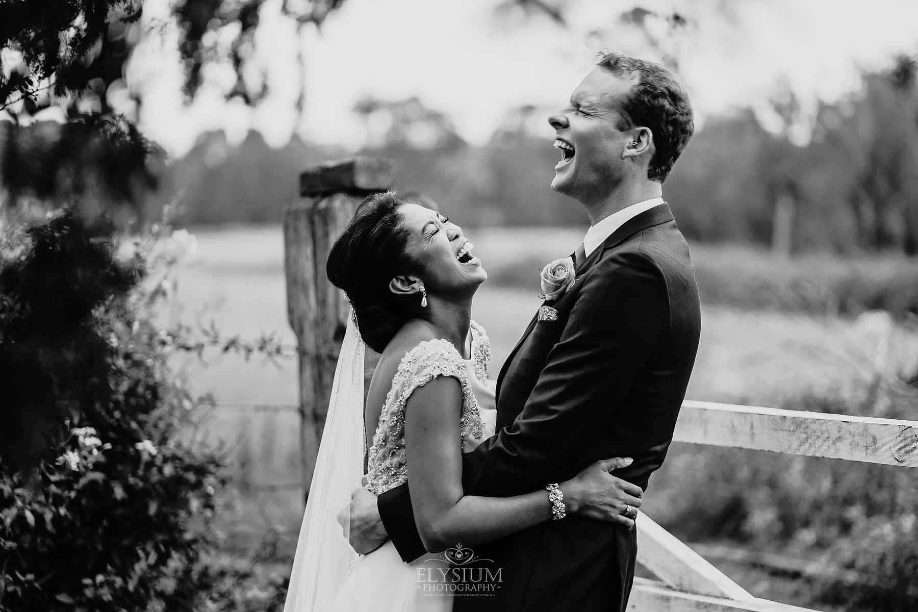 Sydney-Wedding-Photographer-Elysium-Photography-J&M-1 A bride and groom stand against a rustic gate laughing at Gledswood