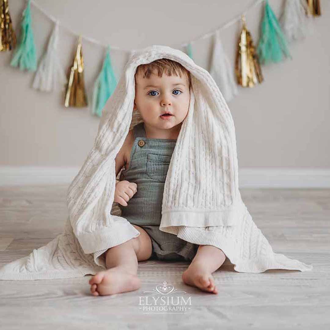Elysium-Photography-Sydney-Baby-Photographer-Isaac-15 A little girl lays on a white fur rug cuddling her newborn baby sister