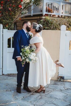 Sydney Wedding Photographer - bride pops her foot back as she kisses the groom