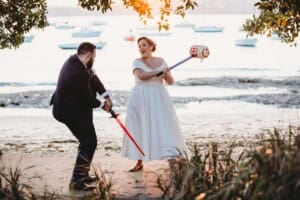 Sydney Wedding Photographer - bride and groom have a mock battle