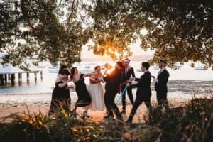 Sydney Wedding Photographer - bridal party have a mock battle