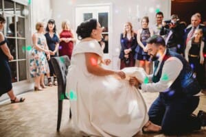 Sydney Wedding Photographer - groom removes the brides garter