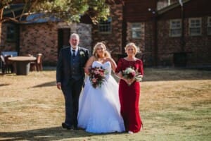 Gledswood Wedding - bride walks to the ceremony with her parents