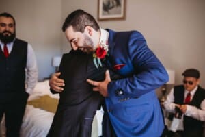 Gledswood Wedding - groom hugs his father