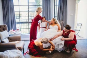 Gledswood Wedding - bridesmaids help the bride with her shoes