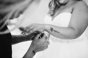 Gledswood Wedding - bridesmaids help the bride with her bracelet