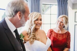 Gledswood Wedding - bride stands with her parents before the ceremony
