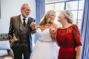 Gledswood Wedding - bride laughs with her parents before the ceremony