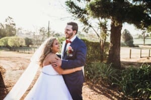 Gledswood Wedding - bride and groom laugh in the venue gardens