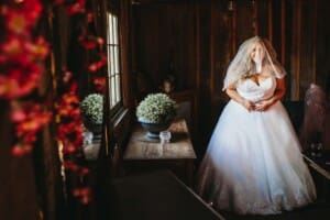 Gledswood Wedding - bride stands in the bridal suite before the reception