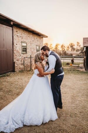 Gledswood Wedding - bride and groom hug as sun sets behind them