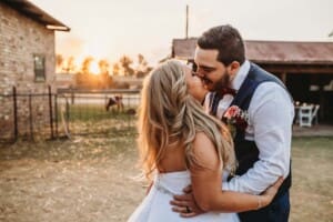 Gledswood Wedding - bride and groom kiss as sun sets behind them