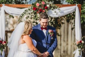 Gledswood Wedding - groom holds his brides hand during the ceremony
