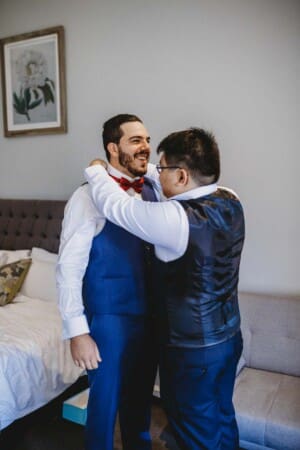Gledswood Wedding - groomsman helps the groom with his tie