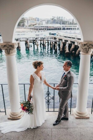 Sydney wedding photographer - Bride and groom stand in Manly pavilion arch