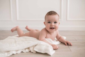 Baby boy grinning cheekily at his mummy