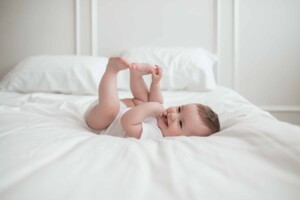 A baby boy playing with his toes