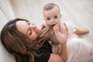 Baby boy chewing on his mamma's hair