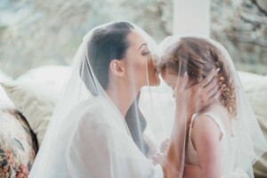 Chapel Hill Wedding - Bride kisses her flower girl under the veil