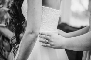 Chapel Hill Wedding - Bridesmaid adjusting the bridal gown