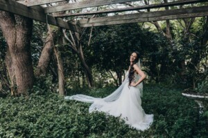 Chapel Hill Wedding - Bride posing surrounded by greenery in a garden