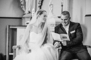 A bride and groom hold hands during the ceremony